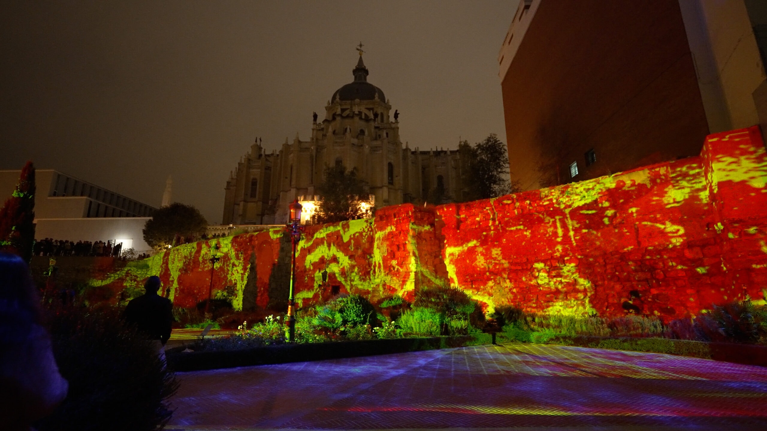 The wall projected in red and yellow with the Almudena behind